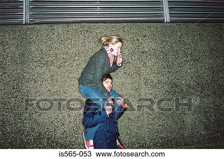 Stock Image - Man shoulder carrying a woman. Fotosearch