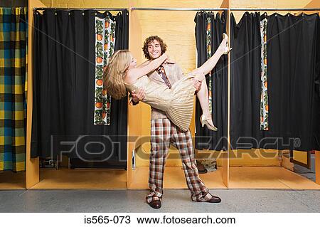 Stock Image - Retro couple dancing in clothes store. Fotosearch