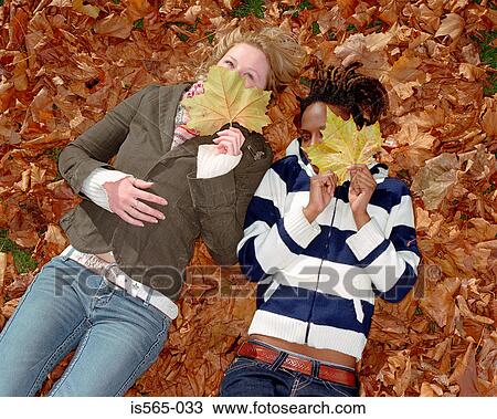 Women lying on leaves View Large Photo Image Stock Image - Women lying on leaves. Fotosearch