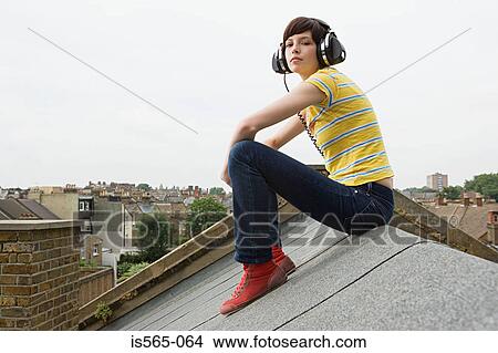 Young woman listening to music on roof View Large Photo Image Picture - Young woman listening to music on roof. Fotosearch