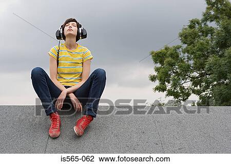 Young woman listening to music on roof View Large Photo Image Stock Image - Young woman listening to music on roof. Fotosearch