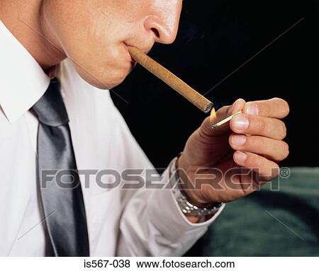 Stock Photo - Businessman lighting a cigar. Fotosearch