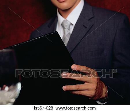 Businessman looking at a menu View Large Photo Image Stock Photo - Businessman looking at a menu. Fotosearch