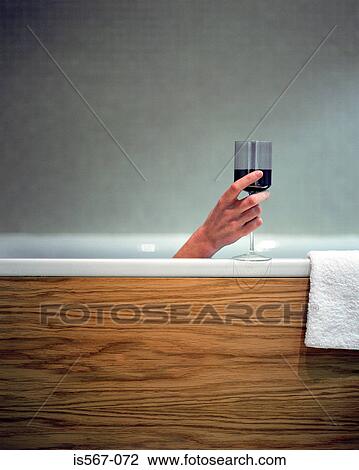Woman holding wine glass in bath View Large Photo Image Stock Image - Woman holding wine glass in bath. Fotosearch