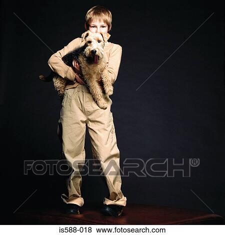 Boy holding pet dog View Large Photo Image Stock Photo - Boy holding pet dog. Fotosearch