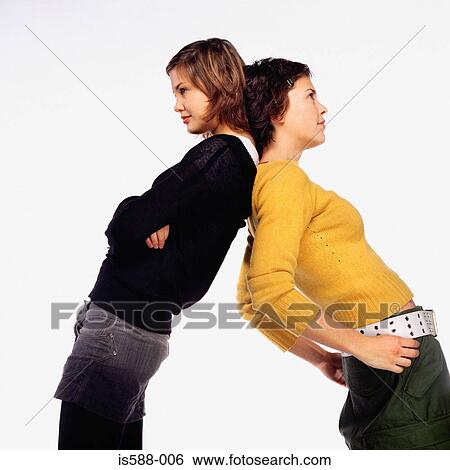 Young women standing back to back View Large Photo Image Stock Photograph - Young women standing back to back. Fotosearch