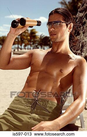 Man using binoculars on beach View Large Photo Image Stock Image - Man using binoculars on beach. Fotosearch