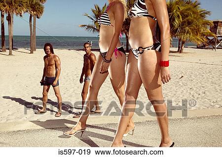 Stock Photo - Men watching women on beach. Fotosearch