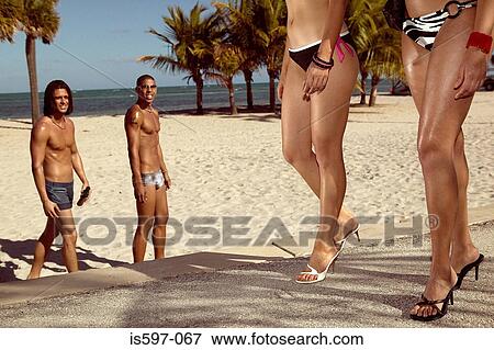 Stock Photo - Men watching women on beach. Fotosearch