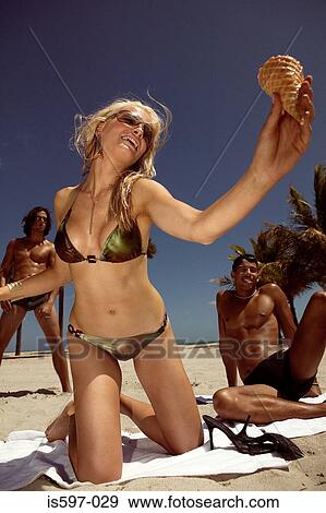 Woman holding ice cream cone on beach View Large Photo Image Stock Photo - Woman holding ice cream cone on beach. Fotosearch