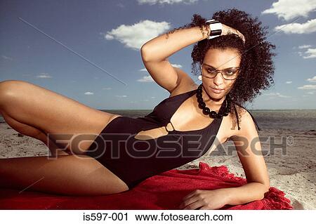 Stock Image - Woman sunbathing on beach. Fotosearch
