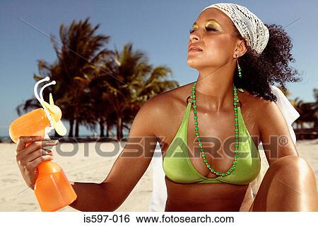 Woman using fan on beach View Large Photo Image Stock Photograph - Woman using fan on beach. Fotosearch