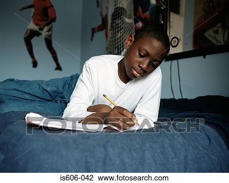 Boy doing homework on bed View Large Photo Image Stock Image - Boy doing homework on bed. Fotosearch