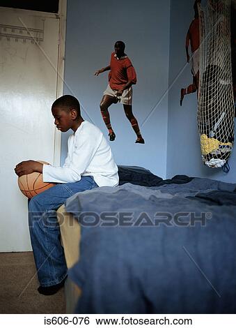 Boy holding basketball in bedroom View Large Photo Image Stock Photograph - Boy holding basketball in bedroom. Fotosearch