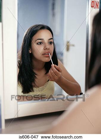 Stock Photo - Girl applying lipgloss. Fotosearch