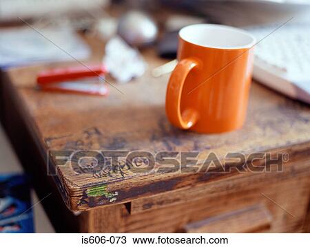 Stock Image - Graffiti and coffee cup on desk. Fotosearch