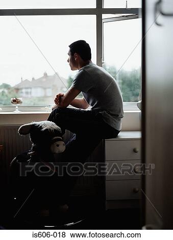 Silhouetted boy near window View Large Photo Image Stock Photo - Silhouetted boy near window. Fotosearch