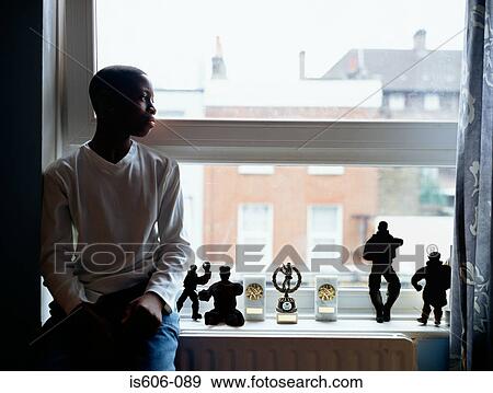 Silhouetted boy near window View Large Photo Image Stock Photo - Silhouetted boy near window. Fotosearch