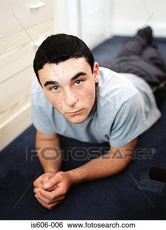 Teenage boy lying in bedroom View Large Photo Image Stock Photograph - Teenage boy lying in bedroom. Fotosearch