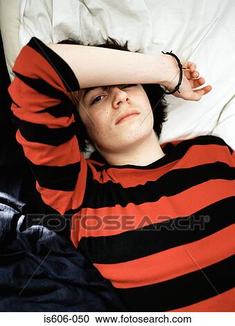 Teenage boy lying on bed View Large Photo Image Stock Image - Teenage boy lying on bed. Fotosearch