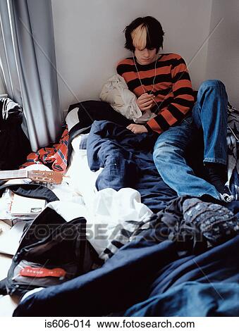 Picture - Teenage boy relaxing on bed. Fotosearch