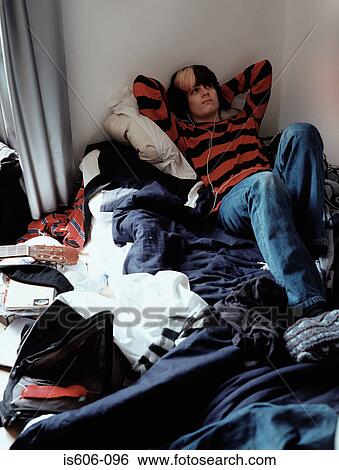 Teenage boy relaxing on bed View Large Photo Image Stock Photograph - Teenage boy relaxing on bed. Fotosearch