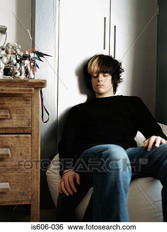 Stock Photograph - Teenage boy sitting on a beanbag. Fotosearch