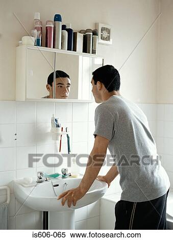 Stock Photography - Teenage boy standing in bathroom. Fotosearch