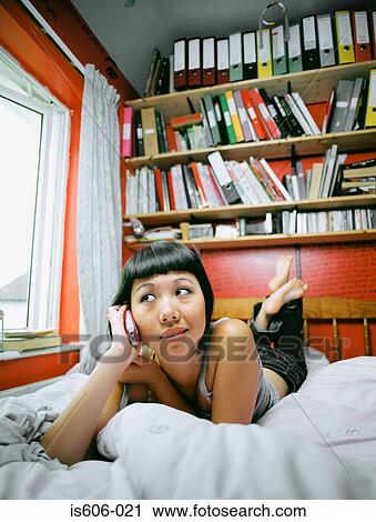 Stock Image - Teenage girl using cellular telephone. Fotosearch
