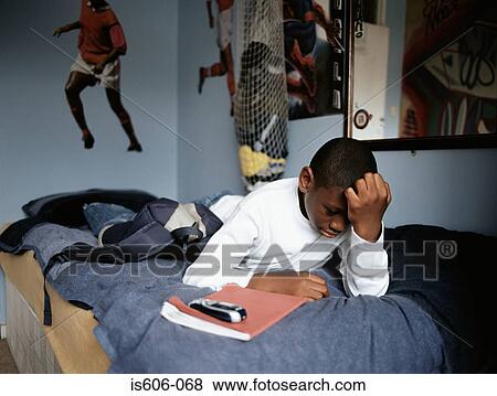 Worried boy lying on bed View Large Photo Image Stock Photo - Worried boy lying on bed. Fotosearch