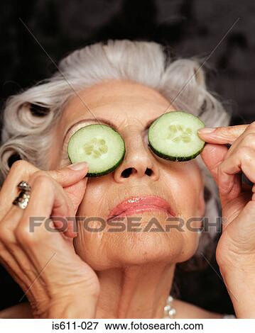 Close-up of woman holding cucumbers over eyes View Large Photo Image Stock Photo - Close-up of woman holding cucumbers over eyes. Fotosearch