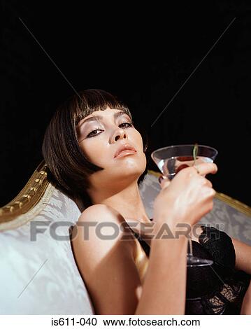 Stock Image - Glamourous young woman drinking a cocktail. Fotosearch