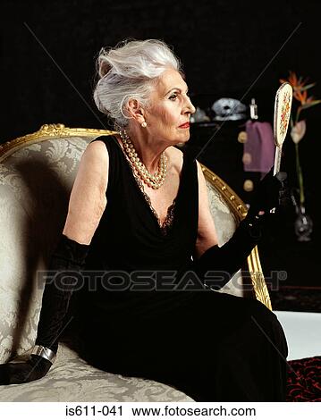 Profile of senior woman looking at herself in a hand mirror View Large Photo Image Stock Image - Profile of senior woman looking at herself in a hand mirror. Fotosearch