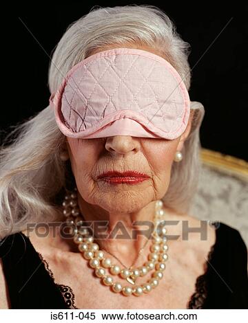 Stock Photography - Senior adult woman wearing pink eye mask . Fotosearch