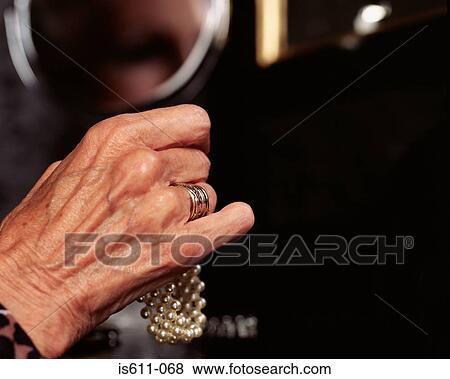 Senior woman holding pearl bracelet View Large Photo Image Stock Photo - Senior woman holding pearl bracelet. Fotosearch