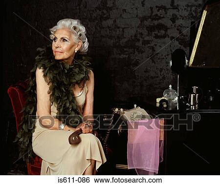 Stock Photograph - Senior woman holding telephone handset . Fotosearch