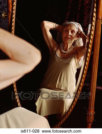 Senior woman looking in the mirror View Large Photo Image Stock Photo - Senior woman looking in the mirror. Fotosearch