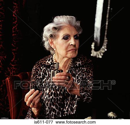 Stock Photo - Senior woman spraying perfume . Fotosearch