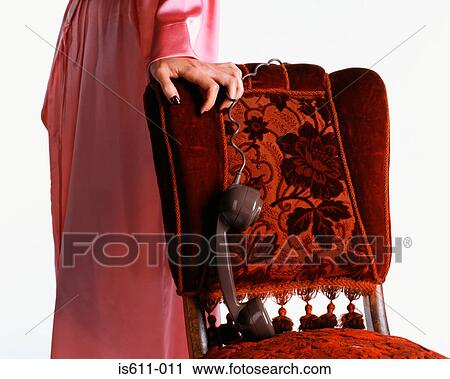 Woman dangling telephone handset over chair View Large Photo Image Stock Image - Woman dangling telephone handset over chair. Fotosearch