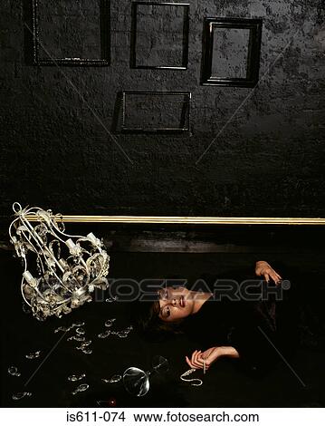 Woman lying on floor with broken chandelier View Large Photo Image Picture - Woman lying on floor with broken chandelier. Fotosearch