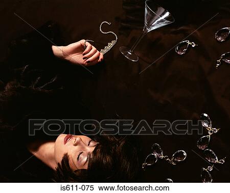 Woman lying on floor with necklace and cocktail glass View Large Photo Image Stock Photography - Woman lying on floor with necklace and cocktail glass. Fotosearch