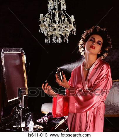Young woman spraying perfume View Large Photo Image Stock Image - Young woman spraying perfume . Fotosearch