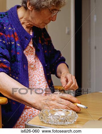 Stock Image - Elderly woman smoking. Fotosearch