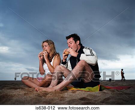 Couple eating hamburgers on beach View Large Photo Image Stock Image - Couple eating hamburgers on beach. Fotosearch