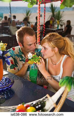 Couple sharing cocktail View Large Photo Image Stock Photograph - Couple sharing cocktail . Fotosearch