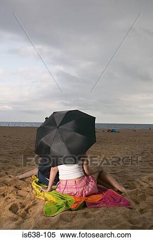 Stock Photography - Couple with umbrella on beach . Fotosearch