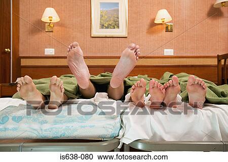Four pairs of feet in a bed View Large Photo Image Stock Image - Four pairs of feet in a bed . Fotosearch