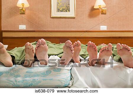 Four pairs of feet in a bed View Large Photo Image Stock Photo - Four pairs of feet in a bed. Fotosearch