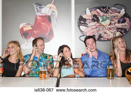 Friends in a bar on mobile phones View Large Photo Image Stock Photo - Friends in a bar on mobile phones. Fotosearch
