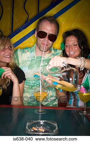 Man and two women drinking in a bar View Large Photo Image Stock Image - Man and two women drinking in a bar. Fotosearch